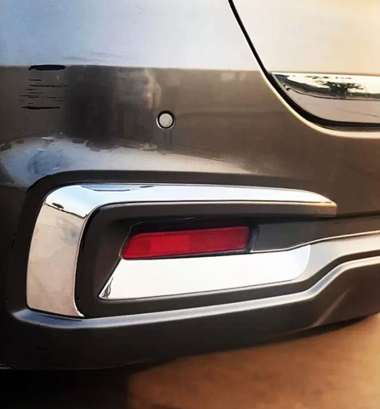 Close-up view of the chrome finish on the Acrylonitrile Butadiene Styrene (ABS) Reflector Lamp garnish installed on a grey Maruti Suzuki Ertiga (2018-2021 model) rear bumper.